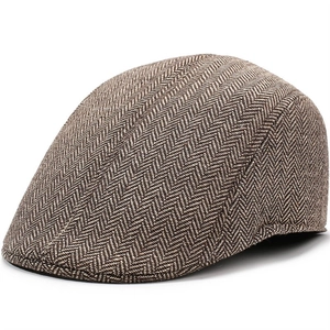 Close-up of the vintage brown herringbone wool texture on the warm ivy flat cap