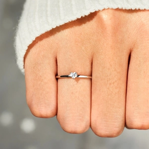 Minimalist S925 sterling silver heart zircon ring worn on finger with soft white sweater
