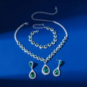 Detail shot of elegant green rhinestone necklace, bracelet, and teardrop earrings set