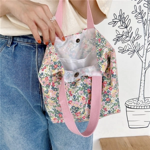 Detail of floral canvas tote bag showing metal snap button and inner storage pocket