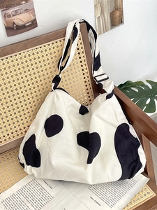 Corduroy cow print hobo bag with large capacity and adjustable wide strap on chair