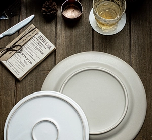 Flat lay of ceramic steak plates with circular texture on vintage wooden background