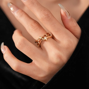Gros plan d'une bague étoile dorée avec pierres claires portée à l'index par un mannequin