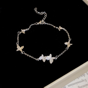 Close-up of silver butterfly bracelet with sparkling zircon stones on black velvet background