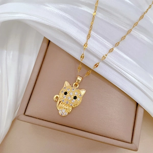 Detailed view of luxury cat pendant with sparkling zircons on gold-tone titanium chain