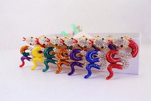 Close-up of snake keychains in seven colors with sparkling rhinestones and gold plating