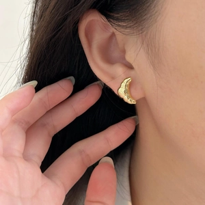 Elegant gold croissant stud earrings with ribbed texture for a minimalist French look