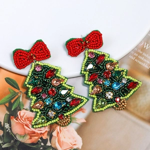 Detail of beaded Christmas tree earrings with a red bow and colorful rhinestones