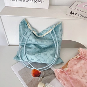 Detailed macro view of quilted texture with bow patterns on pink and blue tote bags