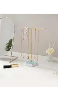 Detail of T-bar jewelry display stand with golden metal rack and marble texture base