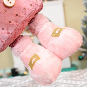Close-up of pink plush boots with gold sequins and plaid fabric on a Christmas doll