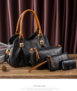 Detailed view of black and brown PU leather bag set with gold hardware on wooden desk