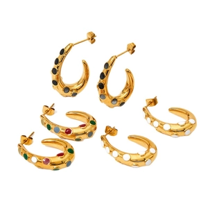 Three pairs of gold-plated C-shaped enamel earrings in black, multicolor, and white