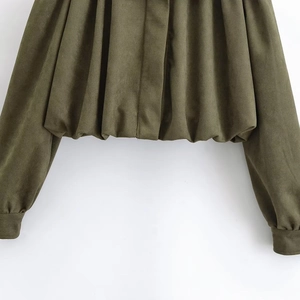 Detail of army green suede jacket showing elastic pleated hem and soft fabric texture
