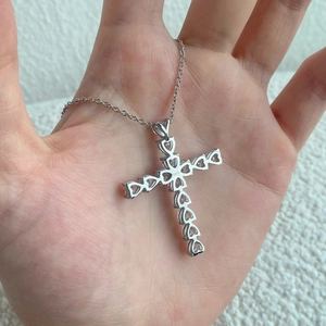 Detailed view of S925 sterling silver stamp on the back of a cross pendant with pearl