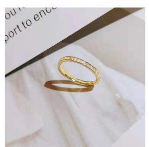 Detail of a thin gold titanium steel ring featuring a row of sparkling cubic zirconia