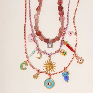Bohemian multilayer necklace set with sun, moon, and pink crystal on white background