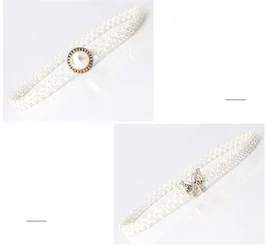 Detail der eleganten weißen Perlen-Tailienkette mit funkelnder Strass-Schmetterlingsschnalle