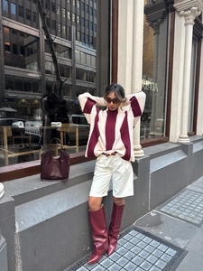 Detail of a chic striped turtleneck sweater with burgundy and cream contrast color blocking