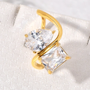 Close-up of 18K gold-plated bypass ring featuring large pear and emerald cut diamonds