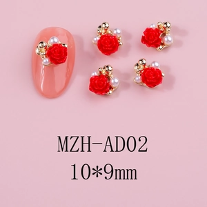 Detail of red rose nail art charms with pearls and golden beads on a soft pink background