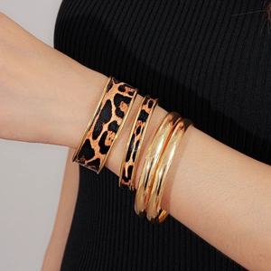 Gros plan de bracelets superposables en cuir léopard avec bordure en métal doré
