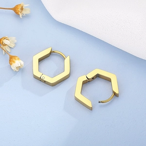 Vue détaillée de boucles d'oreilles hexagonales dorées avec finition métallique polie