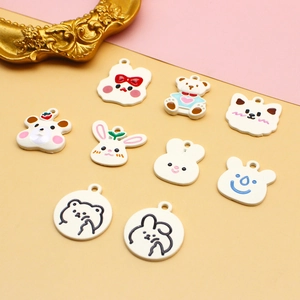 Detail view of nine white enamel animal charms for DIY jewelry and hair accessories