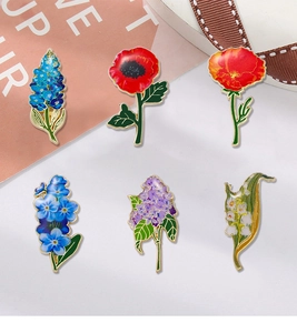 Collection of colorful enamel flower brooches featuring lily of the valley and lilac