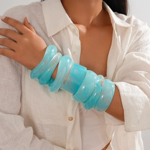 Minimalist blue resin marble bangle with white veins worn in a stylish layered look