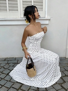 Detail of white off-shoulder polka dot dress with woven bag for elegant summer resort style