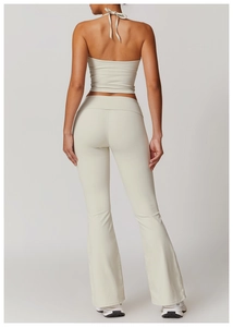 Back view of beige halter yoga set featuring high-waisted flared pants and open back top