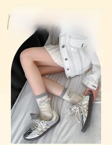 Detail of beige crew socks with pink elephant pattern and grey contrast cuff on model