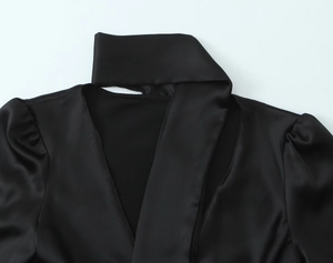 Detail of black satin shirt featuring a V-neck, halter design, and elegant puff sleeves