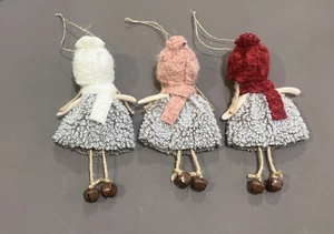 Detailed close-up of three handmade Christmas dolls with colorful hats and metal bells