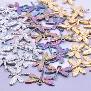 Macro shot of stainless steel dragonfly pendants in gold, silver and rainbow finishes