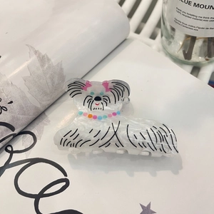 Detail of white marble acrylic hair claw clip featuring a cartoon dog with pink bow tie