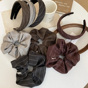 Detailed view of striped scrunchies and headbands on a wooden tray with coffee