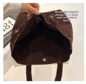 Close-up of the spacious brown suede tote interior with magnetic clasp closure