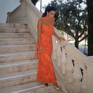 Détail d'une robe longue bustier orange à fleurs avec foulard assorti en décor extérieur