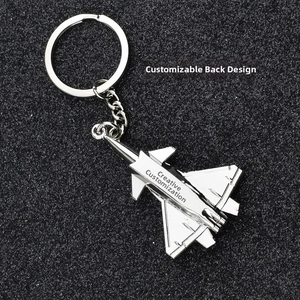 Detailed close-up of a silver fighter jet keychain made of zinc alloy on a black background