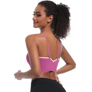 Detail view of pink sports bra featuring cross V-back straps and contrast piping
