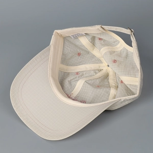 Close-up of quick-dry plaid fabric texture and interior pink embroidery on baseball cap