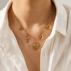 Gold stainless steel necklace with sun, heart, shell, and cross charms worn on neck