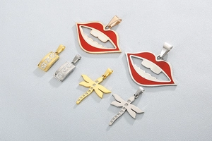 Detailansicht der Libellen-, rote Lippen- und Buchstaben-Anhänger in Gold und Silber