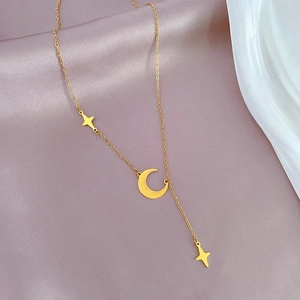 Detail of gold star and crescent moon pendants on soft satin fabric for women