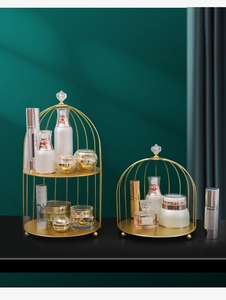 Close-up of golden birdcage makeup rack with crystal ball top and metal fence detail