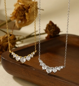 Macro shot of micro-pave gradient zircon smile necklaces in gold and silver finishes