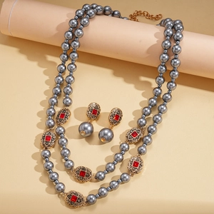 Detail der vintage doppellagigen grauen Perlenkette mit roten Edelstein-Ohrringen