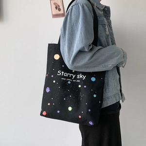 Détail du sac fourre-tout noir en toile avec motif Starry Sky et bandoulière pratique